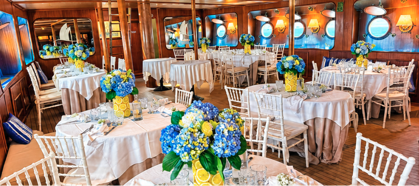 Sala ristorante climatizzata del Veliero Tortuga con allestimenti floreali azzurri e tavole eleganti
